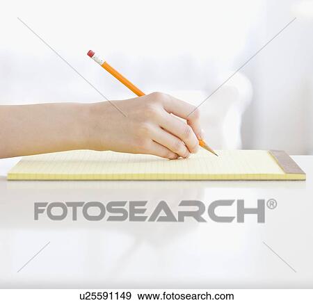 Stock Photo - Woman writing on notepad. Fotosearch