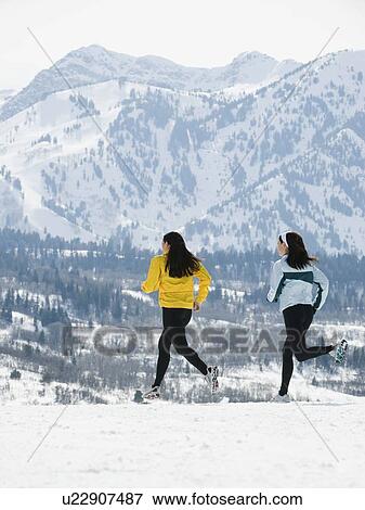 Stock Photo - Women running in snow. Fotosearch