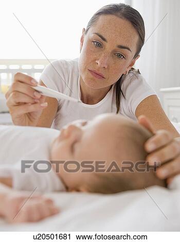 Worried mother checking baby son’s temperature View Large Photo Image Stock Image - Worried mother checking baby son’s temperature. Fotosearch