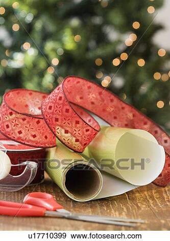 Stock Photo - Wrapping paper, ribbon and scissors on table. Fotosearch