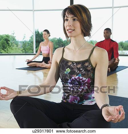 Stock Image - Yoga class in lotus pose. Fotosearch