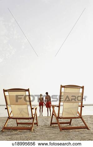 Young couple holding hands on beach View Large Photo Image Stock Photograph - Young couple holding hands on beach. Fotosearch