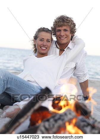 Young couple hugging by campfire on beach View Large Photo Image Stock Image - Young couple hugging by campfire on beach. Fotosearch