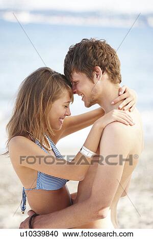 Young couple hugging on beach View Large Photo Image Stock Image - Young couple hugging on beach. Fotosearch