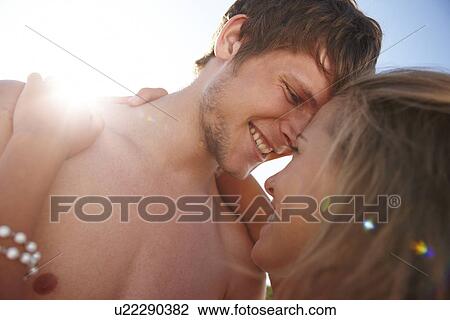 Stock Image - Young couple hugging on beach. Fotosearch