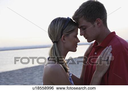 Stock Photograph - Young couple hugging on beach. Fotosearch