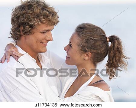 Stock Photography - Young couple hugging on beach. Fotosearch
