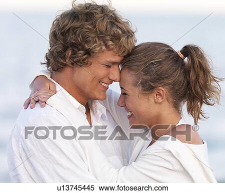 Stock Photography - Young couple hugging on beach. Fotosearch