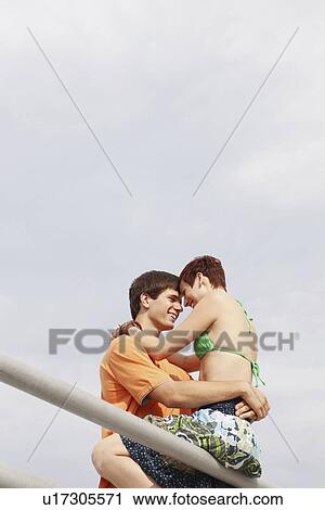 Young couple hugging on boardwalk railing View Large Photo Image Stock Image - Young couple hugging on boardwalk railing. Fotosearch