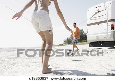 Young couple playing soccer on beach View Large Photo Image Stock Photo - Young couple playing soccer on beach. Fotosearch
