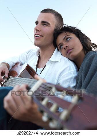 Picture - Young couple relaxing on beach. Fotosearch