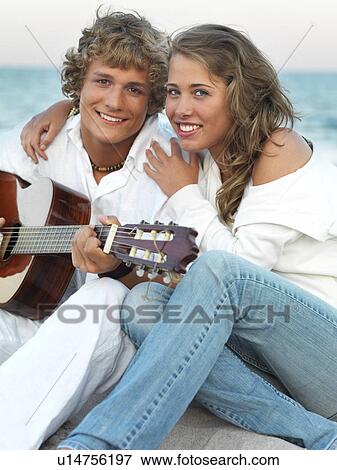 Stock Photo - Young couple relaxing on beach. Fotosearch