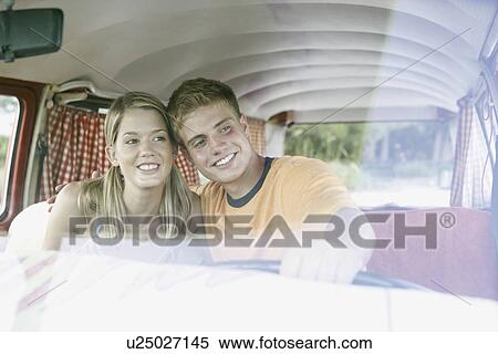 Stock Photography - Young couple sitting in van on beach. Fotosearch