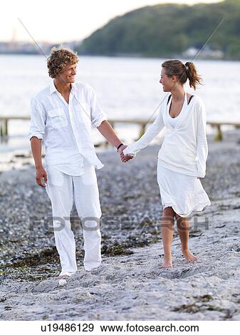 Stock Photo - Young couple walking on beach. Fotosearch