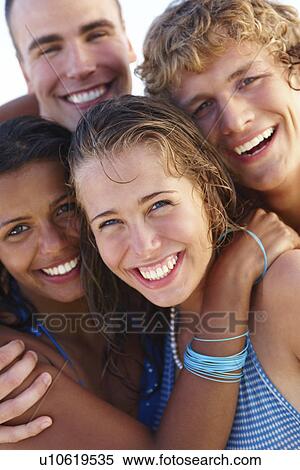 Stock Photography - Young couples hugging on beach. Fotosearch