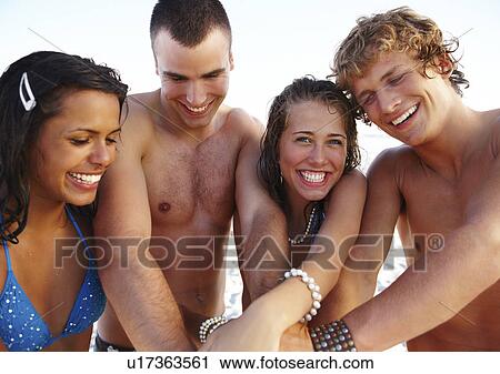 Young couples stacking hands on beach View Large Photo Image Stock Image - Young couples stacking hands on beach. Fotosearch