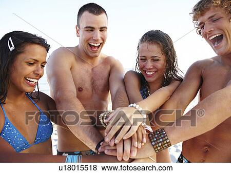 Young couples stacking hands on beach View Large Photo Image Stock Photo - Young couples stacking hands on beach. Fotosearch