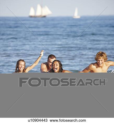 Young friends playing football in ocean View Large Photo Image Stock Image - Young friends playing football in ocean. Fotosearch