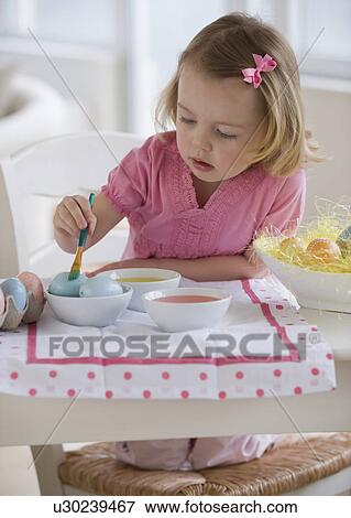 Stock Photo - Young girl decorating eggs. Fotosearch