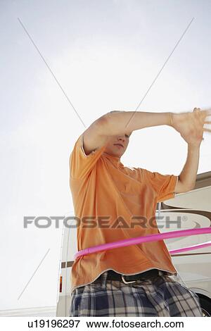 Stock Photo - Young man hula hooping. Fotosearch