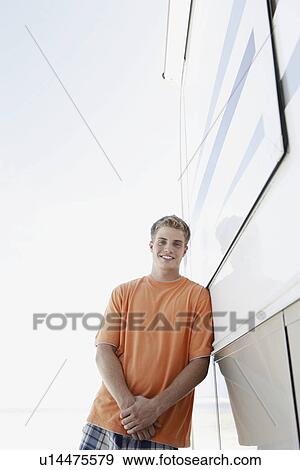 Stock Photo - Young man leaning against motor home. Fotosearch