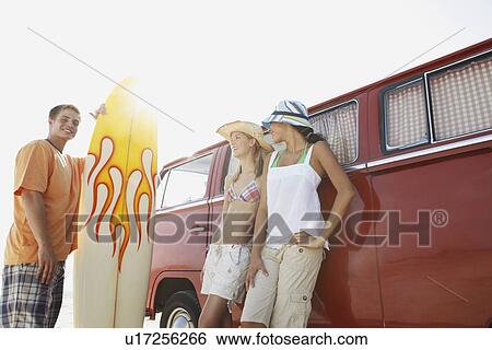 Young man with surfboard and women leaning against van View Large Photo Image Stock Photograph - Young man with surfboard and women leaning against van. Fotosearch