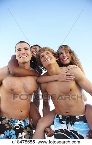 Stock Photography - Young men carrying girlfriends on backs. Fotosearch