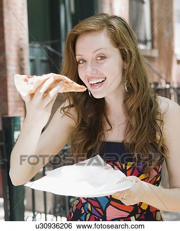 Young woman eating pizza in urban setting View Large Photo Image Stock Photograph - Young woman eating pizza in urban setting. Fotosearch
