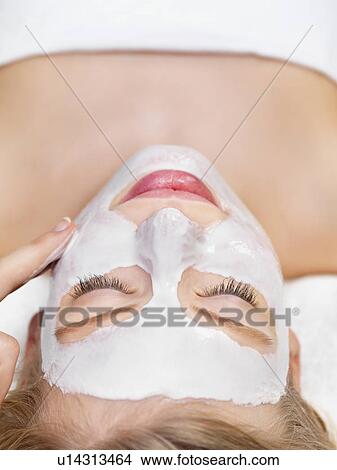 Picture - Young woman getting facial spa treatment. Fotosearch