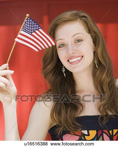 Stock Photo - Young woman holding American flag. Fotosearch