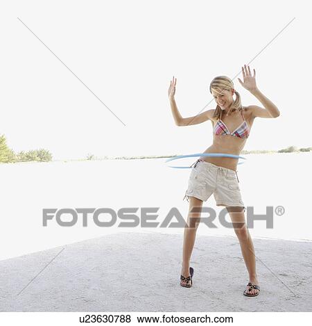Young woman hula hooping on beach View Large Photo Image Stock Photo - Young woman hula hooping on beach. Fotosearch