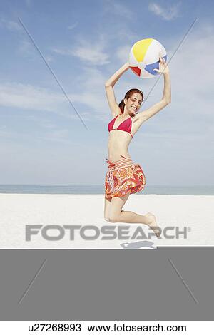 Young woman jumping with beach ball View Large Photo Image Stock Image - Young woman jumping with beach ball. Fotosearch