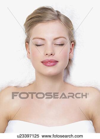 Stock Photography - Young woman lying down on massage table. Fotosearch