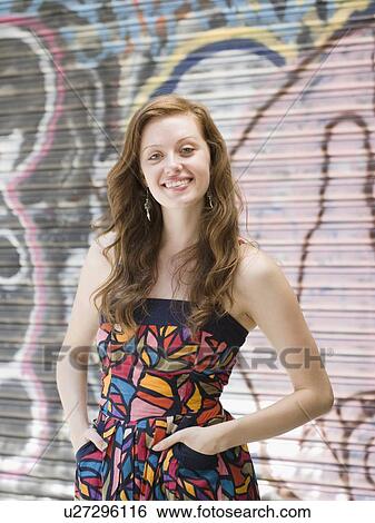Young woman standing in front of graffiti View Large Photo Image Stock Photograph - Young woman standing in front of graffiti. Fotosearch