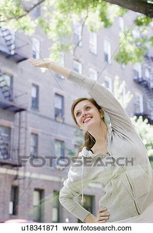 Young woman stretching in urban setting View Large Photo Image Stock Image - Young woman stretching in urban setting. Fotosearch