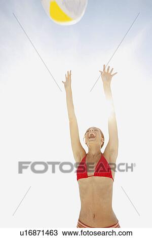 Young woman throwing beach ball in air View Large Photo Image Stock Image - Young woman throwing beach ball in air. Fotosearch