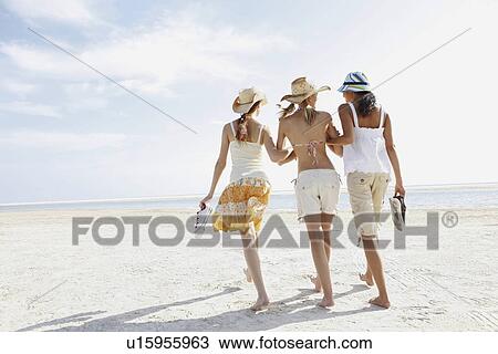 Young women walking on beach View Large Photo Image Stock Image - Young women walking on beach. Fotosearch