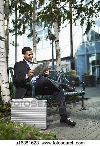 Businessman Reading Newspaper on Bench View Large Photo Image Stock Image - Businessman Reading Newspaper on Bench. Fotosearch