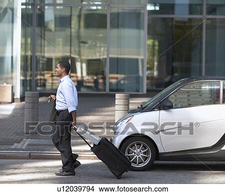 Picture - Businessman Walking by Smart Car . Fotosearch