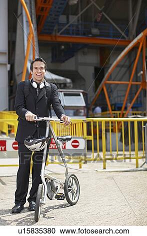 Stock Image - Businessman with Bicycle at Roosevelt Island Tramway. Fotosearch