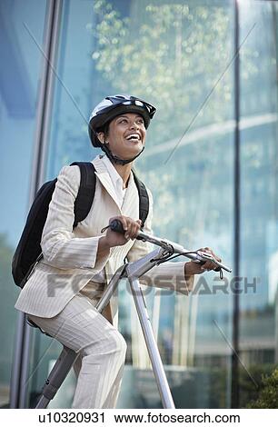 Stock Image - Businesswoman on Folding Bike. Fotosearch