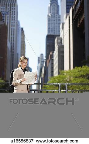 Stock Photo - Businesswoman Reading Map by Railing. Fotosearch