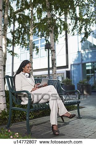 Businesswoman Using PDA on Bench View Large Photo Image Stock Photo - Businesswoman Using PDA on Bench. Fotosearch