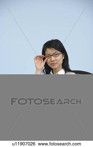 Businesswoman with Eyeglasses Sitting at Desk View Large Photo Image Stock Photograph - Businesswoman with Eyeglasses Sitting at Desk. Fotosearch