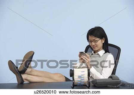 Businesswoman with Feet on Desk Using Cell Phone View Large Photo Image Stock Image - Businesswoman with Feet on Desk Using Cell Phone . Fotosearch