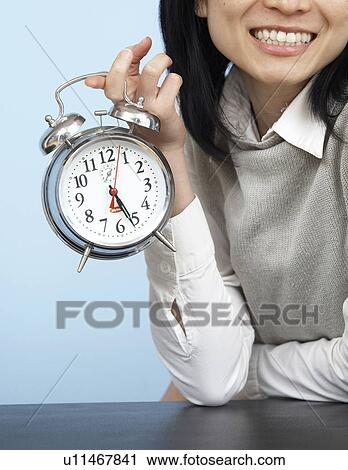 Close-Up of Businesswoman Holding Alarm Clock View Large Photo Image Stock Image - Close-Up of Businesswoman Holding Alarm Clock. Fotosearch
