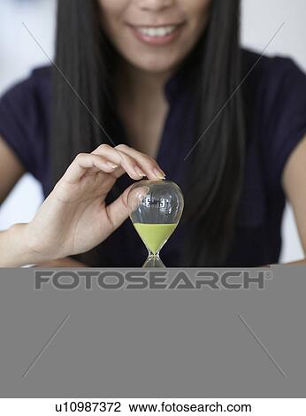 Stock Image - Close-Up of Mid-Adult Woman with Hourglass. Fotosearch