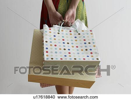 Stock Image - Close-Up of Mid Adult Woman with Shopping Bags. Fotosearch