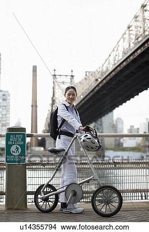 Female Cyclist by Bridge View Large Photo Image Picture - Female Cyclist by Bridge. Fotosearch