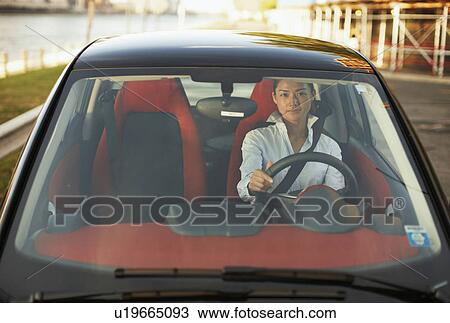 Stock Image - Front View of Mid-Adult Woman Driving Smart Car. Fotosearch